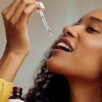 A woman taking a drop of CBD Oil on her tongue
