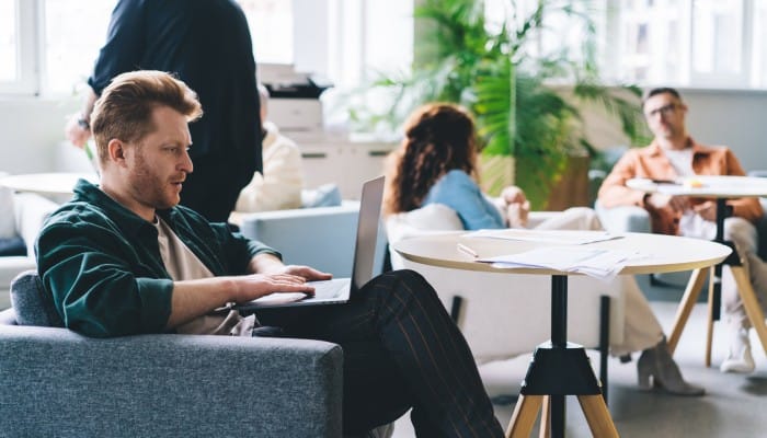 A lounge area in a business office with comfortable seating and free flowing workspace to benefit employees.