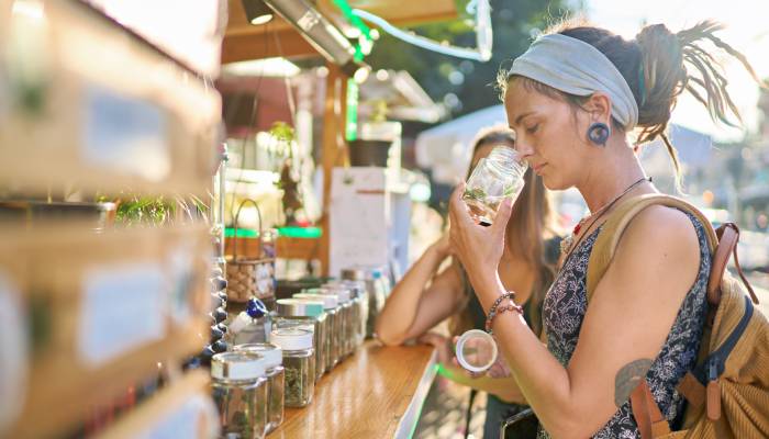 Two female tourists are shopping for marijuana at a legal cannabis shop, and one of them is smelling the product.